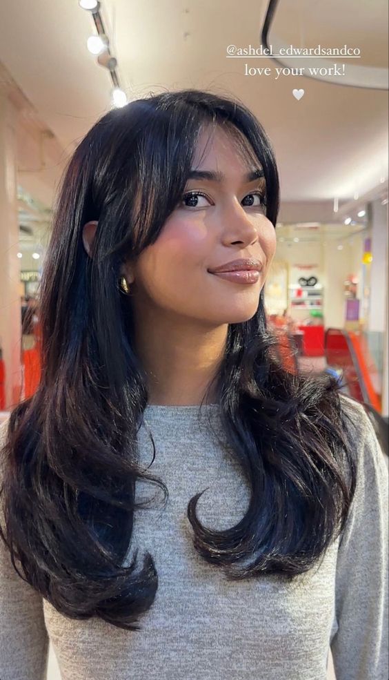 A beautiful woman with long black hair in a Quinceanera store.