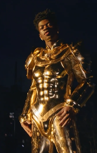 A bronze sculpture of a man in a shiny suit standing in the dark at a Quinceanera celebration