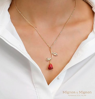A close up of a person wearing a Quinceanera necklace and a red rose earring