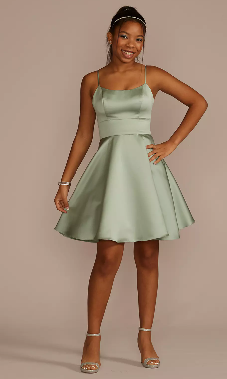 Quinceanera: A woman in a green cocktail dress posing for a picture