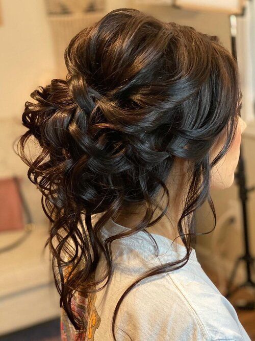 A close up of a person with long hair, showcasing a Quinceanera hairstyle