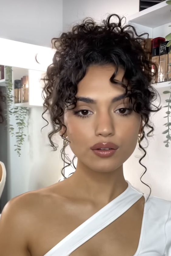 A woman with long curly hair taking a selfie at a Quinceanera